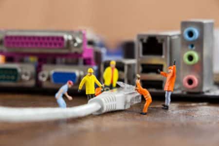 miniature engineer and worker plug in lan cable to computer 1252 839